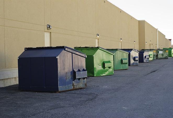 a construction worker moves construction materials near a dumpster in East Rancho Dominguez CA